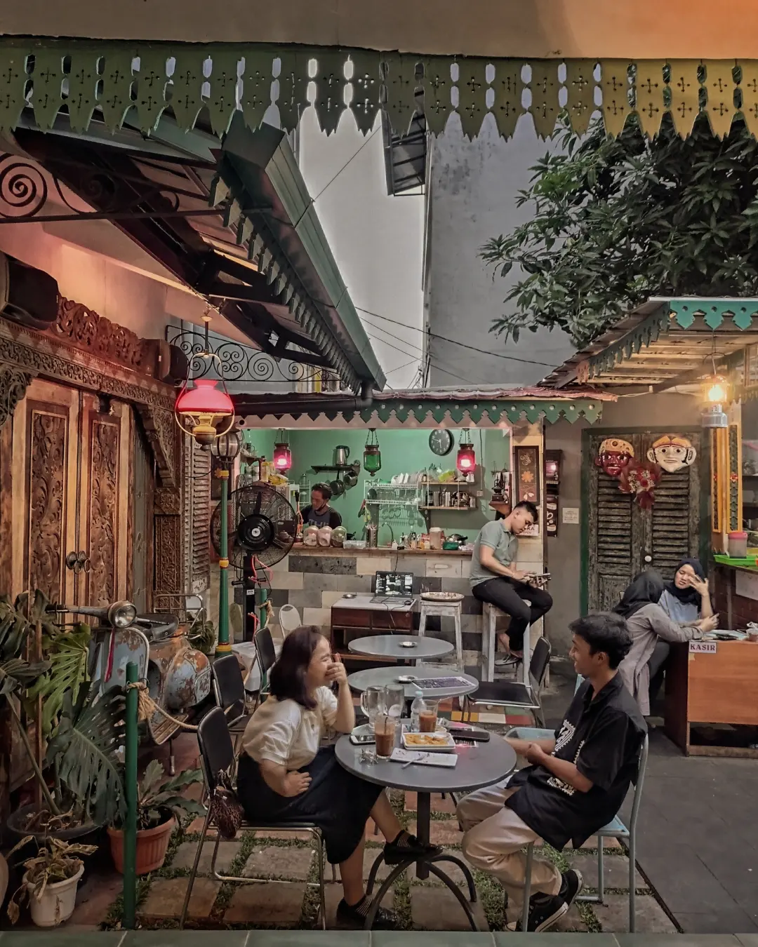Suasana malam Waroeng Daon Lontar dengan lampu hangat dan area duduk outdoor