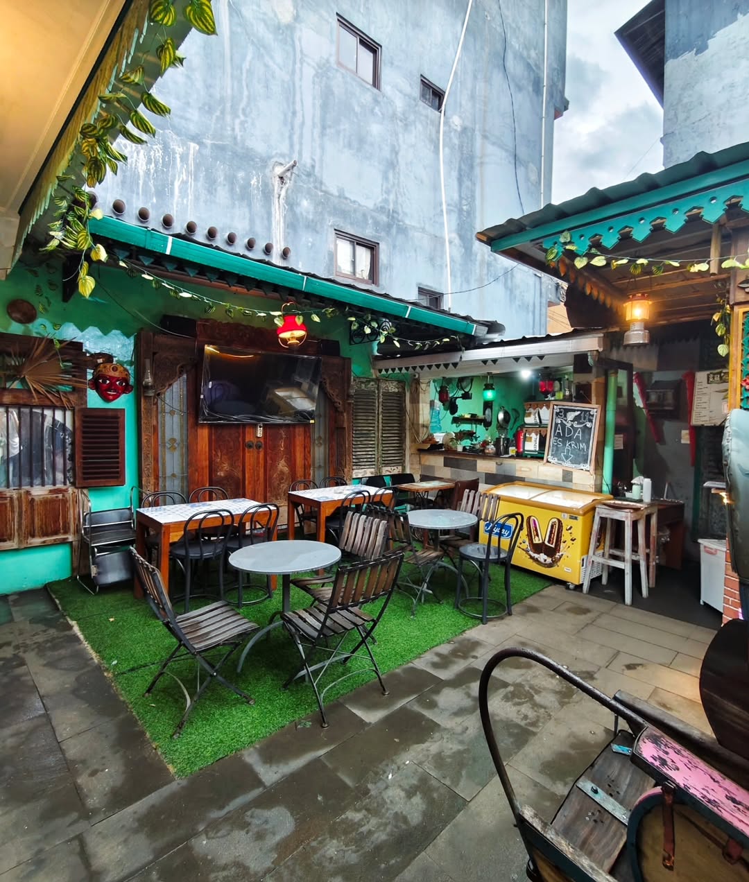 Sudut nongkrong outdoor dengan meja dan kursi vintage